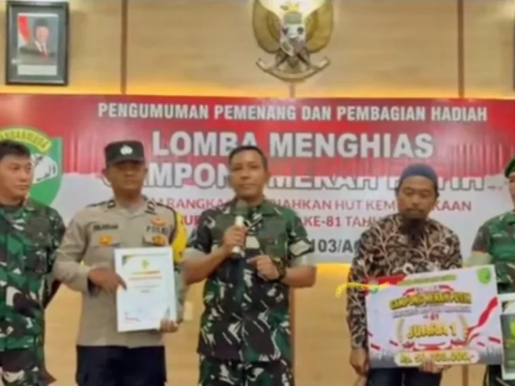 Komandan Kodim 0103/Aceh Utara, Letkol Inf. Faisal, S.Sos., M.Si.,menyerahkan hadiah kepada Desa Suka Damai Kabupaten Aceh Utara sebagai Juara Satu  dengan hadiah Rp. 50.000.000,- (FOTO | DAHLAN HASYIM)