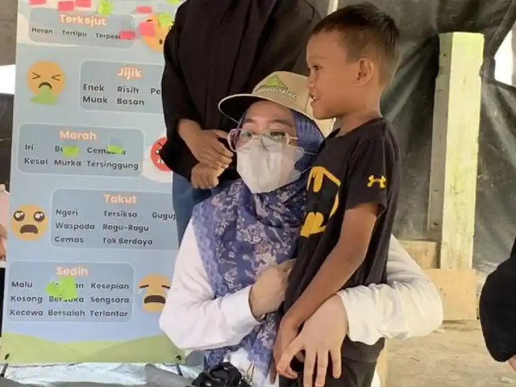 MENANGIS HARU - Relawan psikososial memeluk anak penyintas banjir di Lubuksidup, Aceh Tamiang, Sabtu (18/4/2026). Sebagian anak menangis karena merasa senang dikunjungi tim relawan.